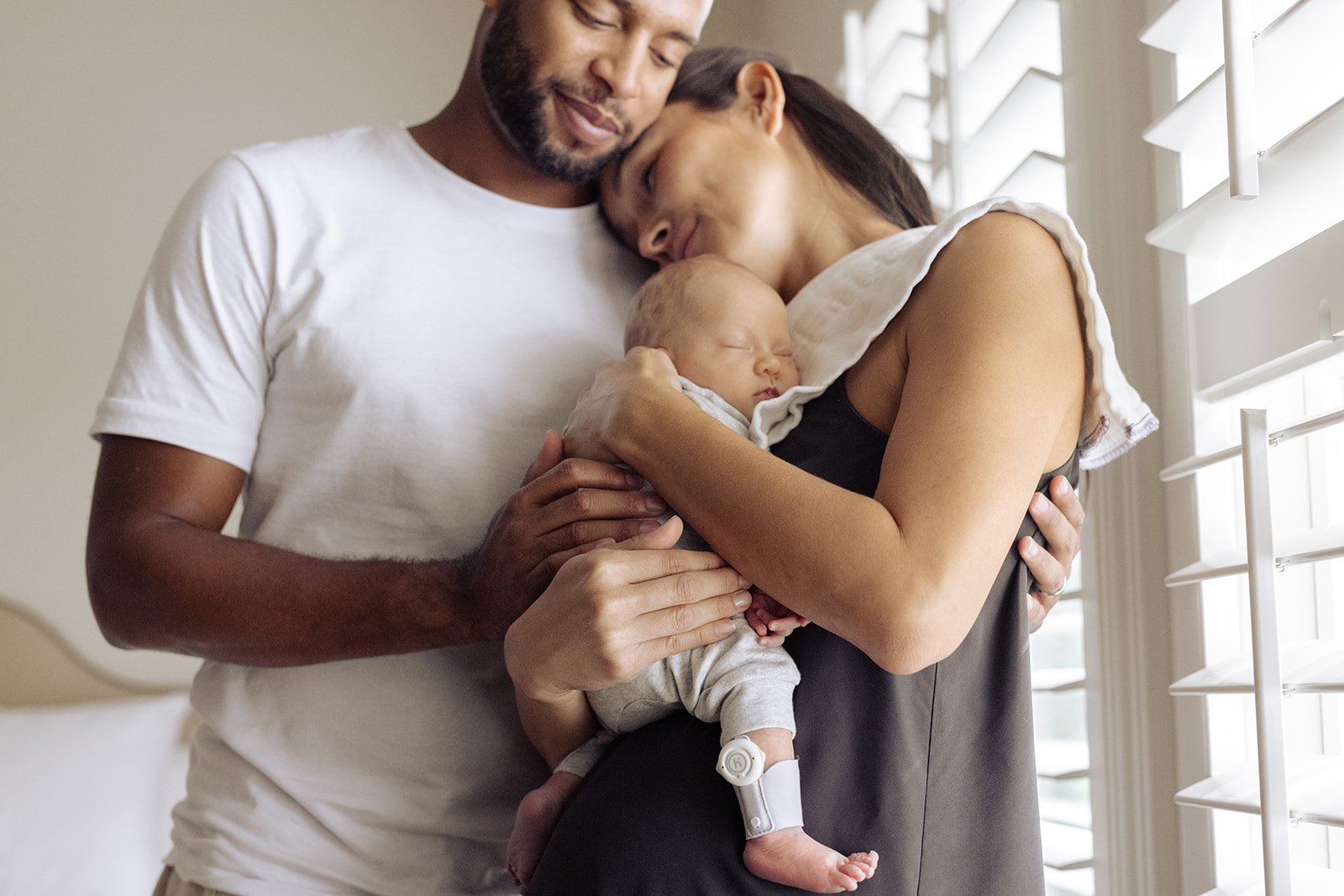 family in bedroom with new baby
