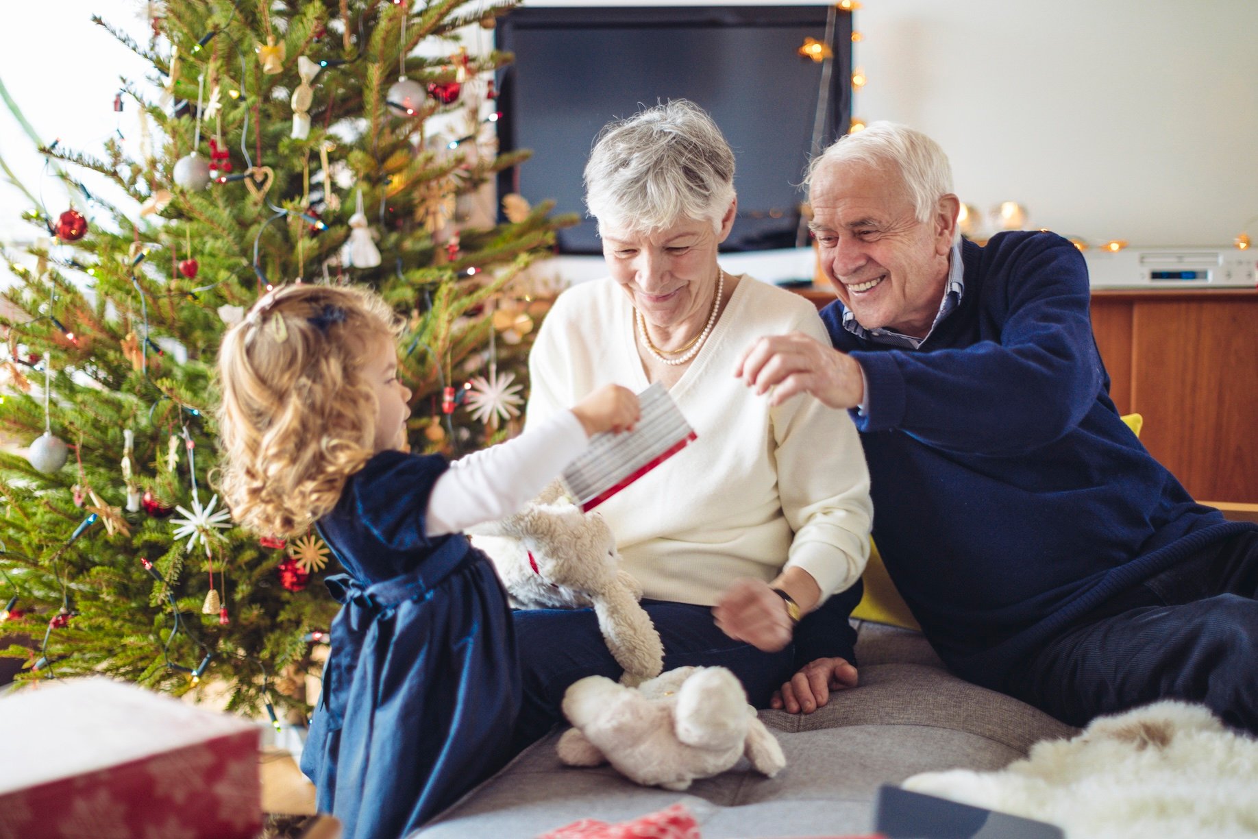 Grandparents giving a young girt her Christmas gifts