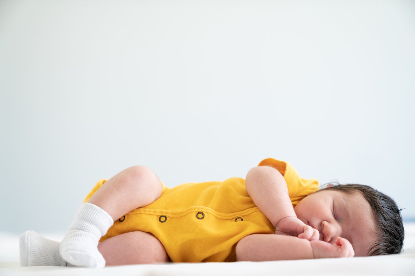 baby sleeping and wearing yellow
