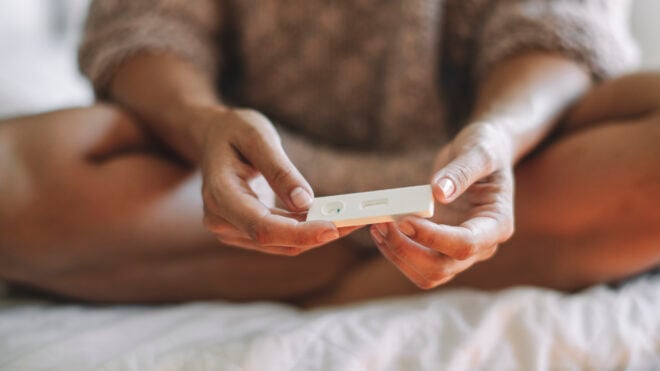 woman holding pregnancy test