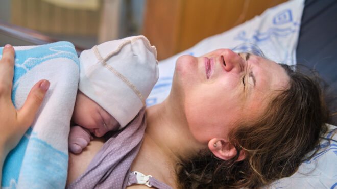 A woman who gave birth to a newborn baby boy. Laying the child out on the mother chest immediately after childbirth, postpartum preeclampsia