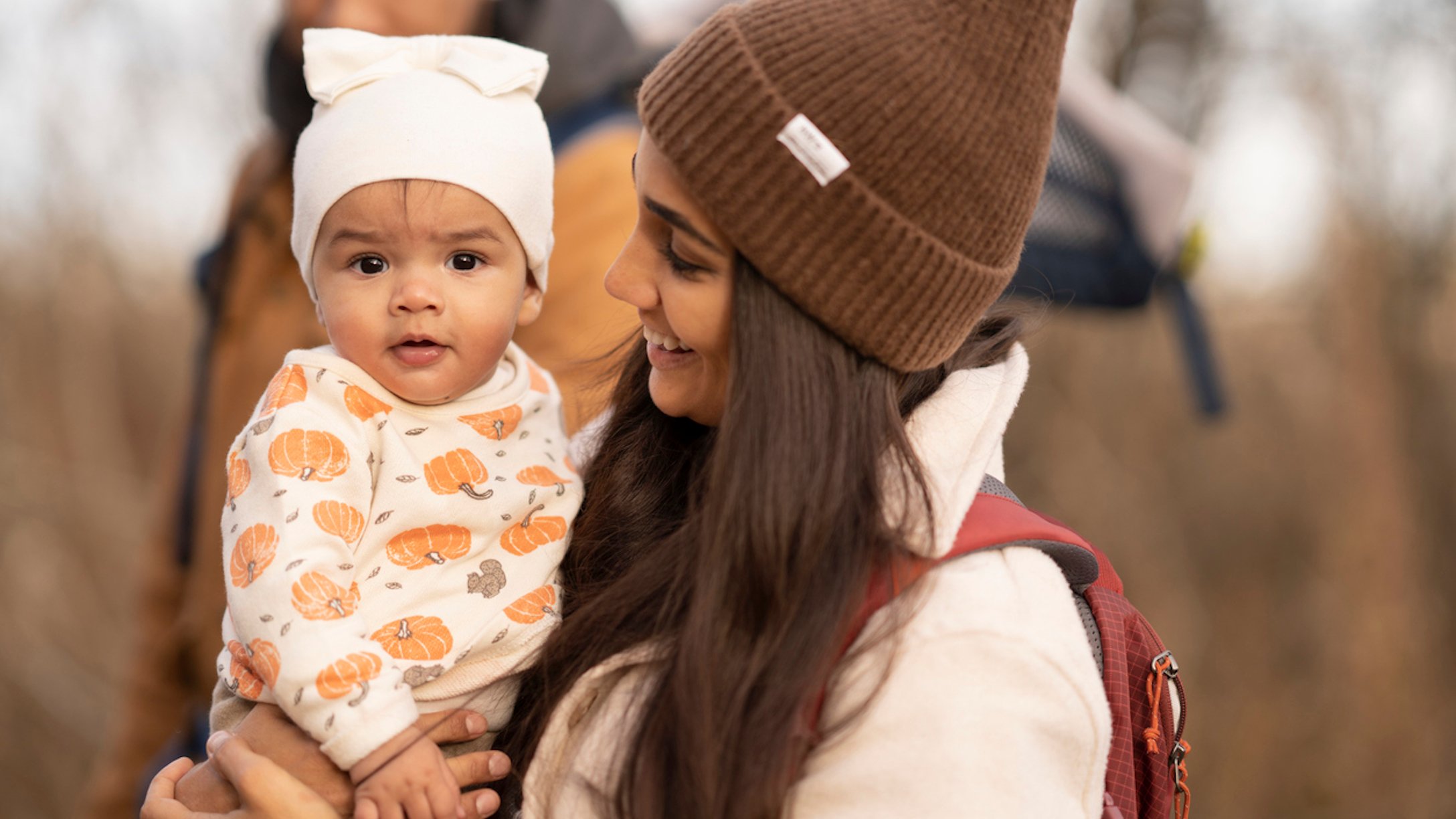 Baby in a pumpkin outfit with mom