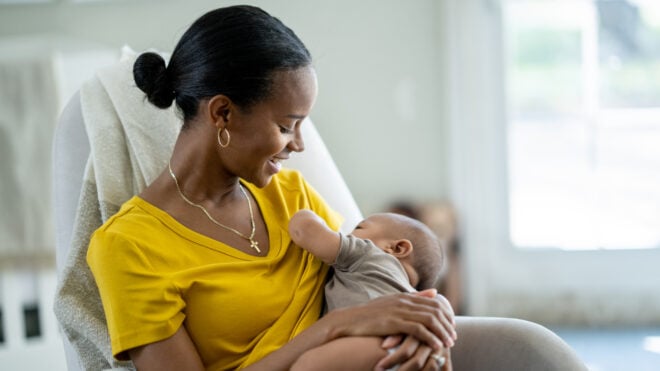 Mom smiling while breastfeeding her new baby