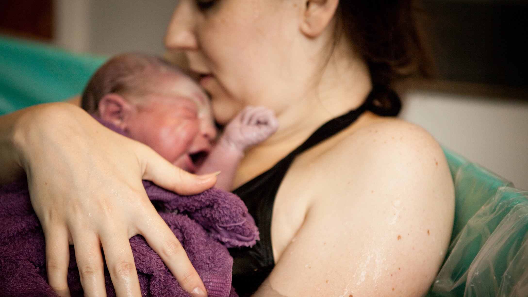 Mother Holding Newborn in Birthing Tub